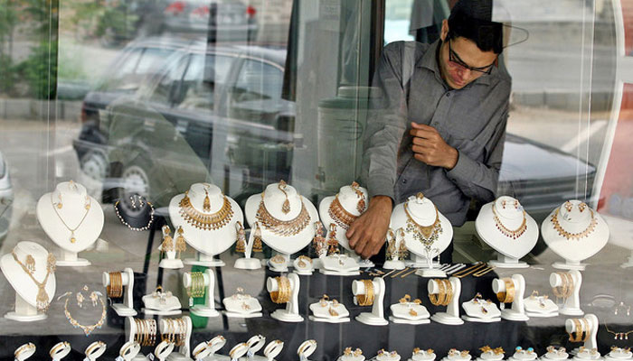A Pakistani shopkeeper arranges jewellery in the window of a jewellery shop in Islamabad. — AFP/File
