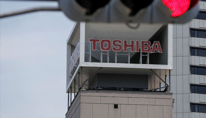 The logo of Toshiba Corp. is seen next to a traffic signal atop a building in Tokyo, Japan June 11, 2021.-Reuters
