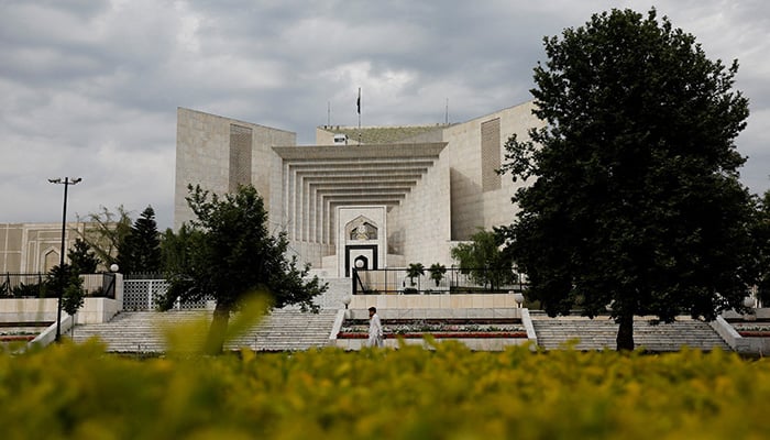 A man uses his mobile phone as he walks past the Supreme Court of Pakistan building in Islamabad, Pakistan May 13, 2023. — Reuters