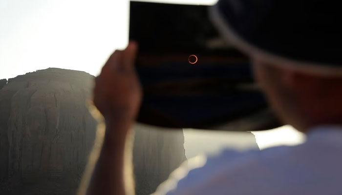 A tourist watches an annular eclipse through a solar viewer in Monument Valley Tribal Park in Utah May 20, 2012.-Reuters