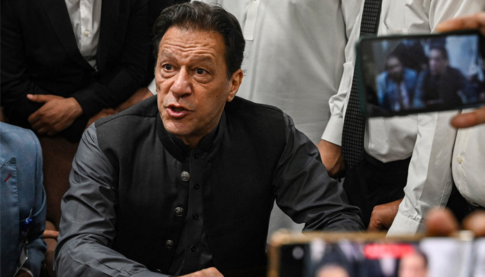 PTI Chairman Imran Khan gestures after arriving at a registrar office in Lahore High court to sign surety bonds for bail in various cases, in Lahore on July 3, 2023. — AFP