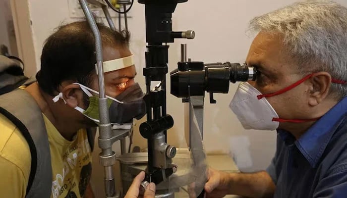 A doctor is checking the eyes of a patient. — AFP/File