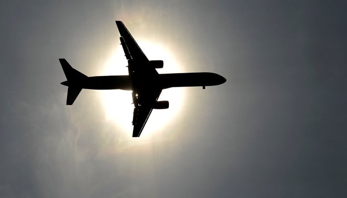 A plane approaching Leeds Bradford airport passes in front of the sun in Leeds May 26, 2013. — Reuters