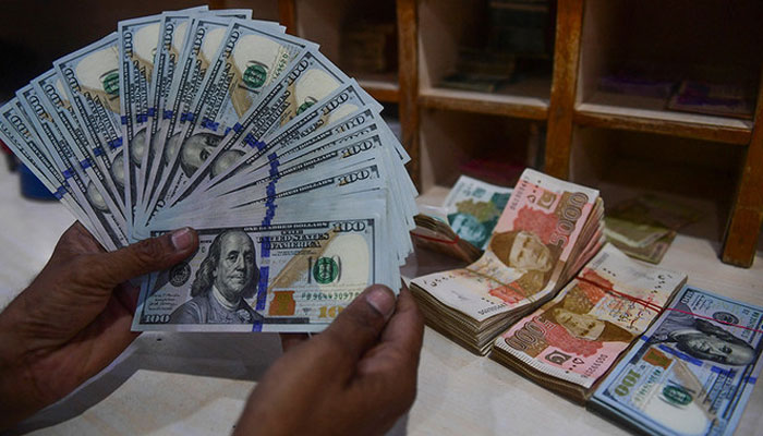 A foreign currency dealer counts US dollars at a shop in Karachi on May 19, 2022. — AFP/File