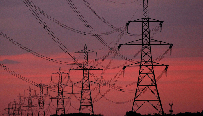 The sun rises behind electricity pylons near Chester, northern England October 24, 2011. — Reuters