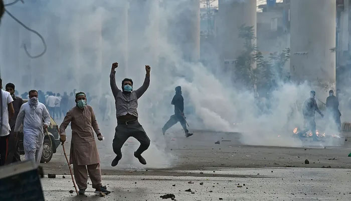 Police use tear gas to disperse supporters of the TLP, during a protest in Lahore on April 12, 2021, after the arrest of their leader. — AFP