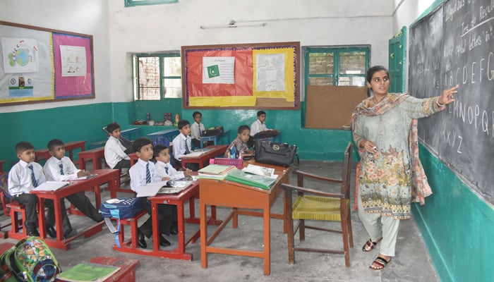 A teacher instructs students during class in Lahore on August 21, 2023. — Online