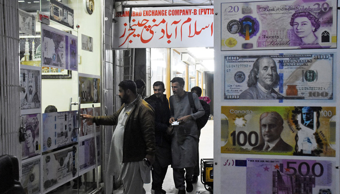 People walk towards a money changer shop in Islamabads Blue Area on January 26, 2023. — Online