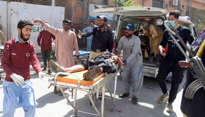 Volunteers carry a blast victim on a stretcher at a hospital in Quetta on September 29, 2023, after a suicide bombing in Mastung district. — AFP