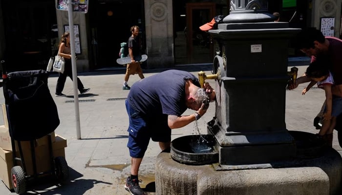 A door-to-door parcel delivery man, cools himself in a fountain during his work, ahead of the first summer heatwave in the centre of Barcelona, Spain June 26, 2023. — Reuters