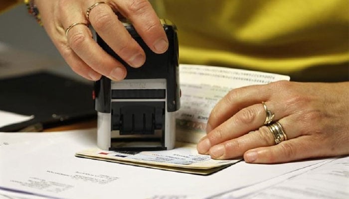 This representational picture shows an officer stamping a passport. — Reuters/File