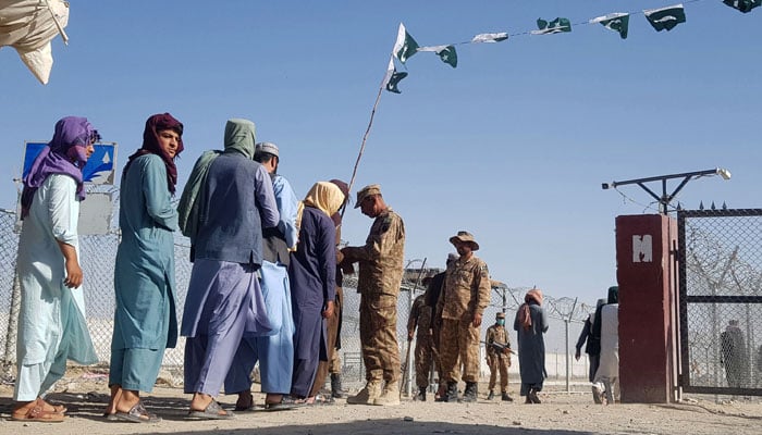 Pakistani soldiers check documents of stranded Afghan nationals returning to Afghanistan at the Pakistan-Afghanistan border crossing point in Chaman on August 14, 2021. — AFP