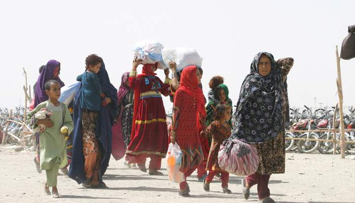 People from Afghanistan walk with their belongings as they cross into Pakistan at the Friendship Gate crossing point, in the Pakistan-Afghanistan border town of Chaman, September 7, 2021. — Reuters