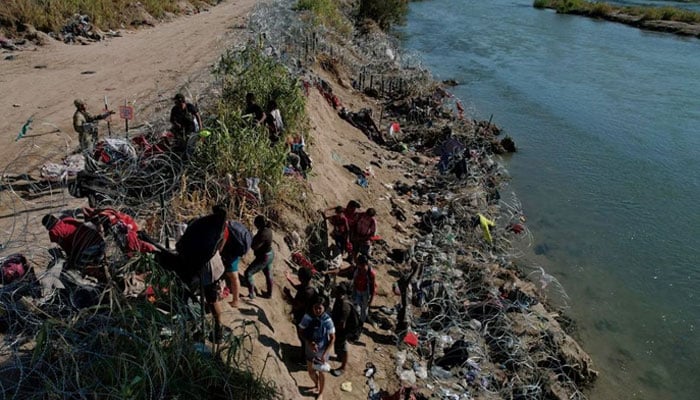 Members of the Texas National Guard try to dissuade migrants from climbing over the razor wire after they crossed the Rio Grande in Eagle Pass, Texas, US, September 29, 2023.—Reuters