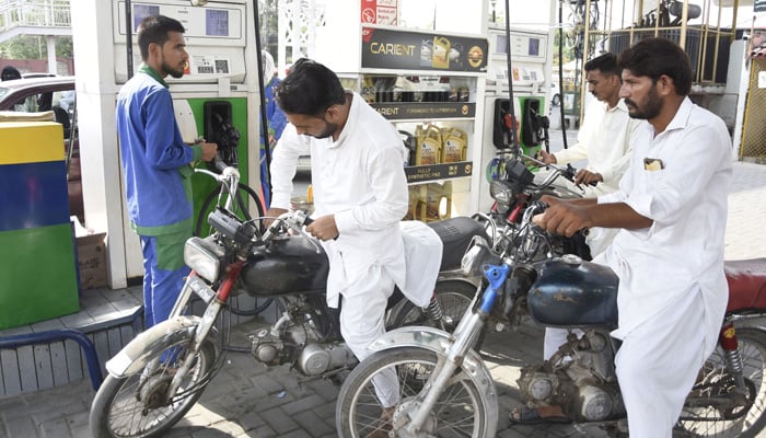 A petrol station attendant fills the tank of a motorcycle at a petrol pump in Rawalpindi on September 1, 2023. — Online