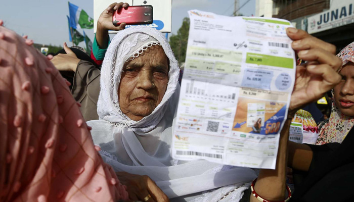 An elderly woman displays her electricity bills during protest against highly inflated electricity bills at the University road in Karachi on Thursday, August 31, 2023. — PPI