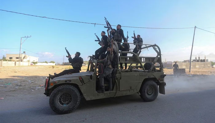 Palestinian militants ride an Israeli military vehicle that was seized by gunmen who infiltrated areas of southern Israel, in the northern Gaza Strip October 7, 2023. — Reuters