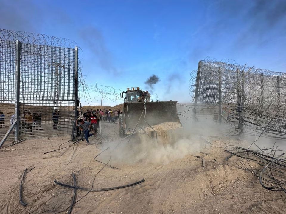 Palestinians break into the Israeli side of Israel-Gaza border fence after gunmen infiltrated areas of southern Israel, October 7, 2023. — Reuters