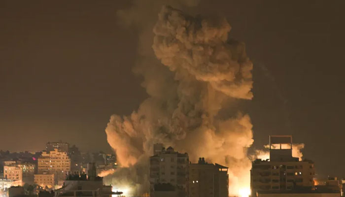 Fire and smoke rise above buildings in Gaza City during an Israeli air strike on October 8, 2023. — AFP