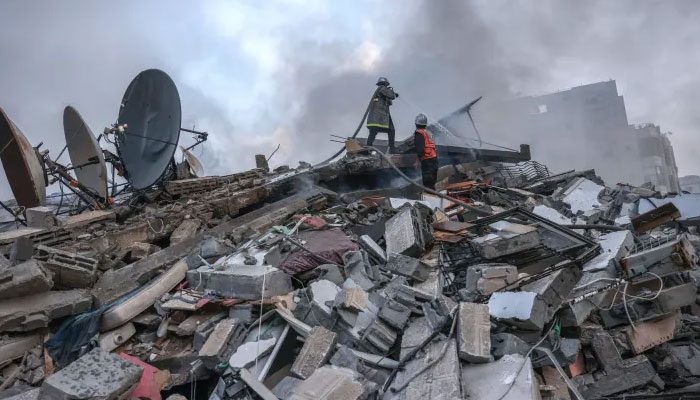 Palestinian firemen extinguish a fire that was raging in a residential building destroyed by Israeli airstrikes in Gaza City on October 8, 2023.—AFP