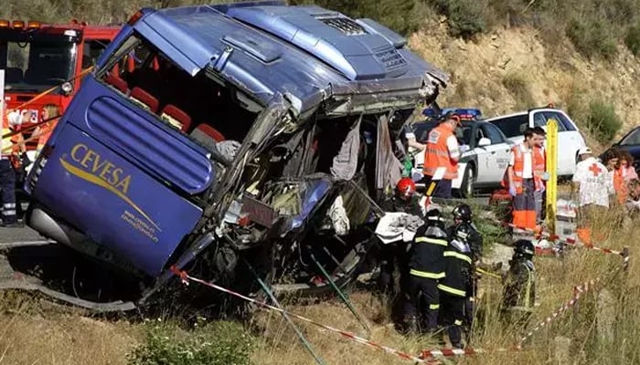 Firefighters recover a body from the wreckage of a bus which crashed near Avila, central Spain. — Reuters/File