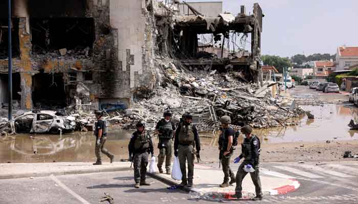 Israeli security gather near a rifle at the site of a battle following a mass infiltration by Hamas gunmen from the Gaza Strip, in Sderot, southern Israel October 8, 2023. —Reuters