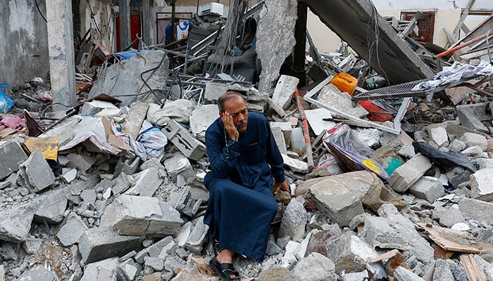 A Palestinian sits on the rubble of a building destroyed in Israeli strikes, in Rafah in the southern Gaza Strip on October 9, 2023. — Reuters