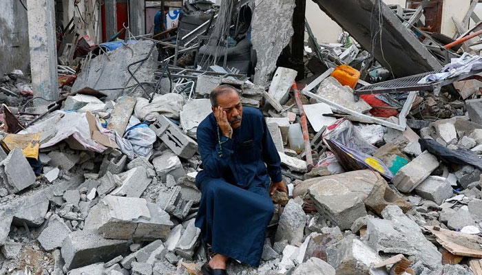 Ένας Παλαιστίνιος κάθεται στα ερείπια ενός κτιρίου που καταστράφηκε στα ισραηλινά χτυπήματα, στη Ράφα στη νότια Λωρίδα της Γάζας, 9 Οκτωβρίου 2023. — Reuters