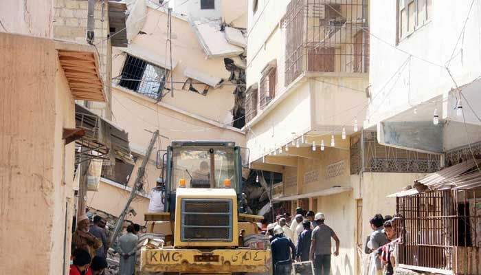 Workers of KMC are busy in rescue work on second day, as the building has caved-in a day before in Golimar No 2. Photo:Online/Sabir Mazhar