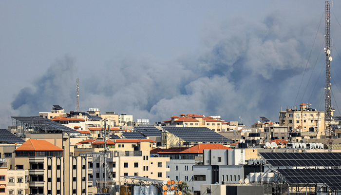 A plume of smoke rises above buildings in Gaza City during an Israeli air strike, on October 8, 2023. —AFP