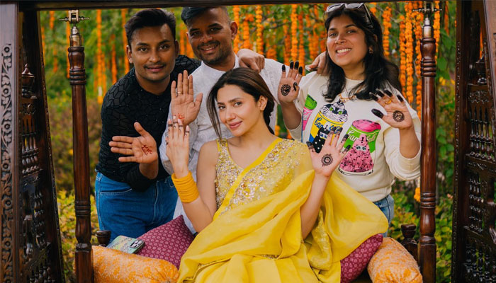 Pakistani actor Mahira Khan (centre) shows off henna while posing with friends. — Instagram/@mahirahkhan