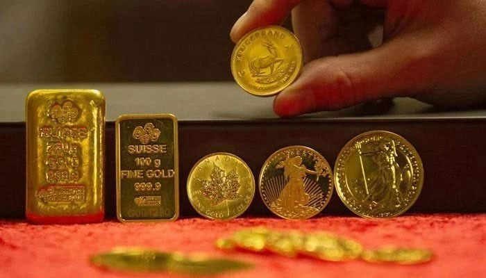 The picture shows gold bars and coins. — AFP/File