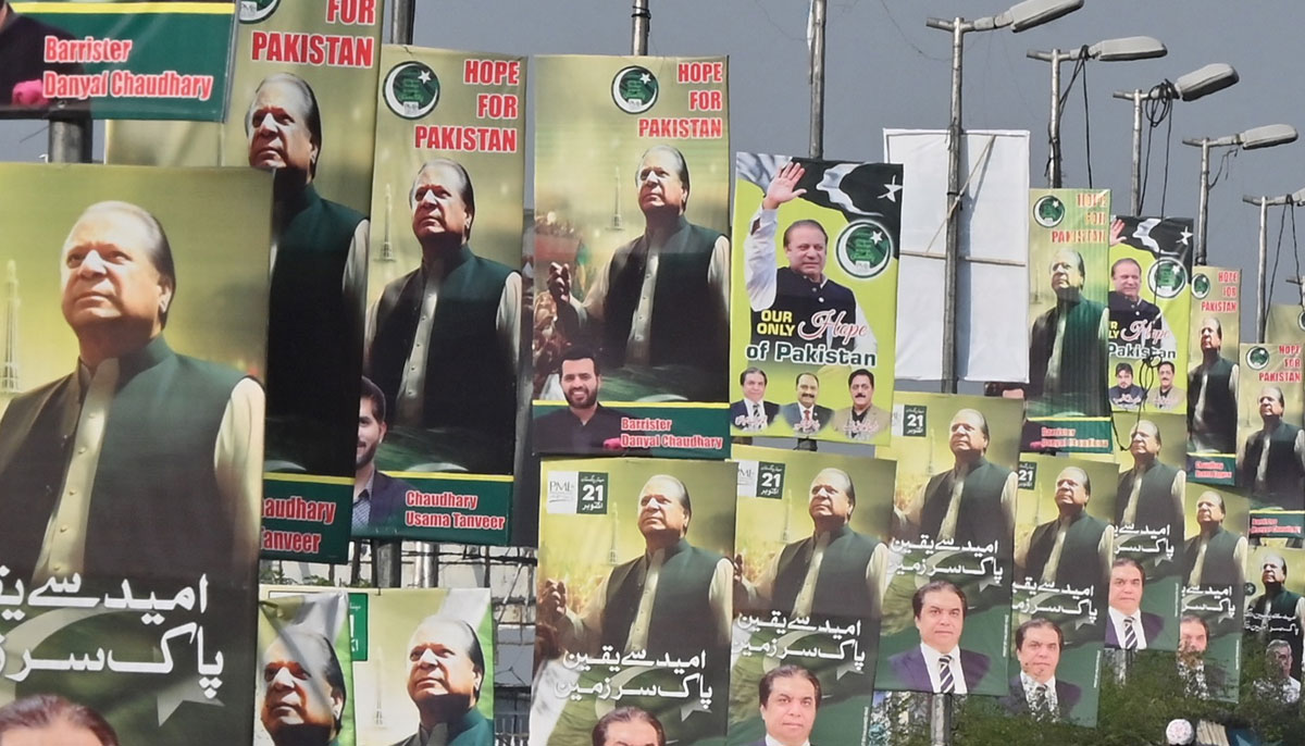 Commuters ride past the welcoming posters of former Pakistan´s Prime Minister Nawaz Sharif, on his return home next week, in Rawalpindi on October 13, 2023. — AFP