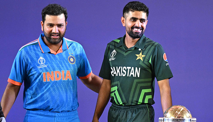 Indias captain Rohit Sharma (left) with Pakistan skipper Babar Azam stand beside the trophy during the Captains Day event at the Narendra Modi Stadium in Ahmedabad, India on October 4, 2023. — AFP