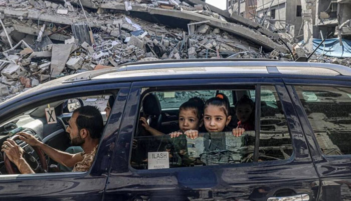 Palestinians drive amid the rubble of buildings destroyed in an Israeli air strike in Rafah, on the southern Gaza Strip. AFP/File