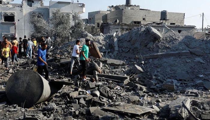 Palestinians search for casualties under the rubble in the aftermath of Israeli strikes, in Khan Younis in the southern Gaza Strip, October 14. —Reuters