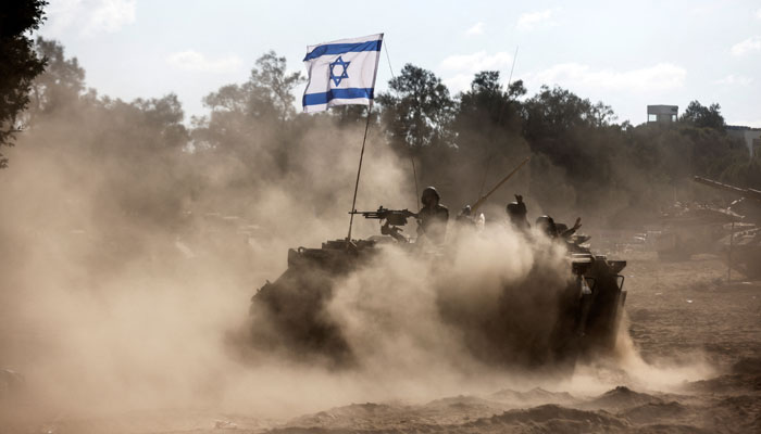 An Israeli Armoured Personnel Carrier (APC) takes position near Israels border with the Gaza Strip, in southern Israel, October 13, 2023. — Reuters