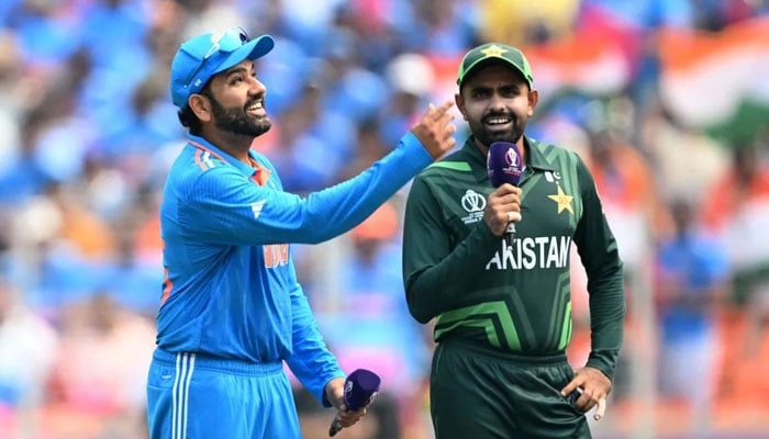 Indian captain Rohit Sharma (left) flips the coin for the toss, while Pakistan skipper Babar Azam looks on ahead of the teams match in the ICC Mens Cricket World Cup 2023 in India on October 14, 2023. — AFP