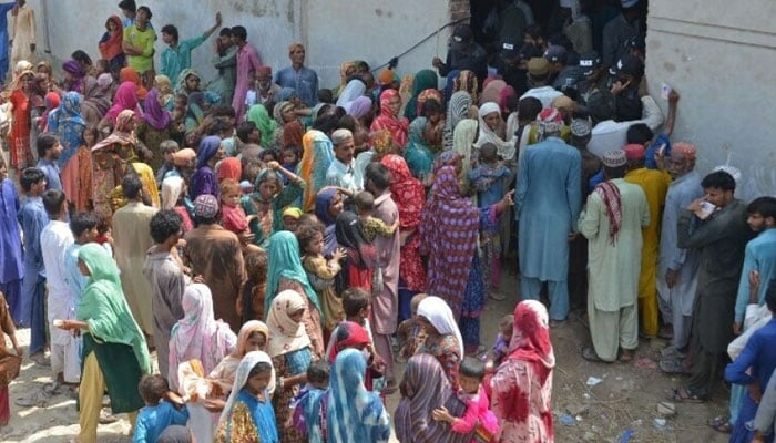 Internally displaced flood-affected people wait to receive charity relief supplies near a makeshift camp at Dera Allah Yar in Jaffarabad district of Balochistan province on September 21, 2022. — AFP
