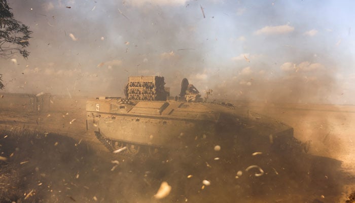 An Israeli armoured personnel carrier (APC) is obscured as it whips up dust near Israels border with the Gaza Strip, in southern Israel October 15, 2023 — Reuters