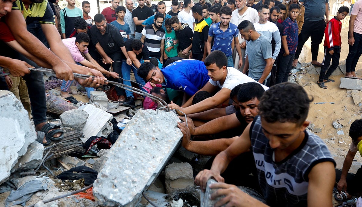 Palestinians search for casualties under the rubble of a house destroyed in Israeli strikes in Khan Younis in the southern Gaza Strip October 16, 2023. — Reuters