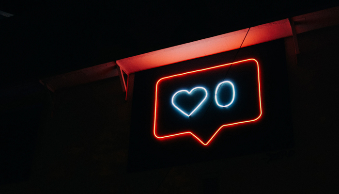 A representational image shows zero likes with a neon sign of a heart. — Unsplash