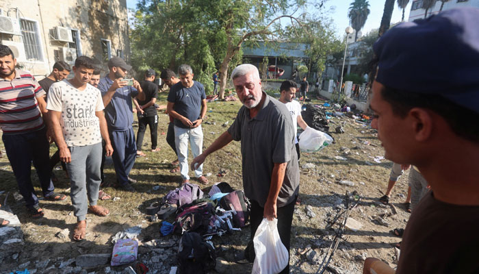 People gather in the area of Al-Ahli hospital where hundreds of Palestinians were martyred. — Reuters