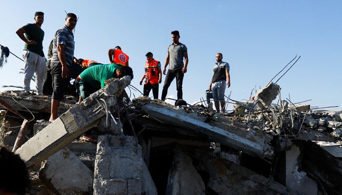 Palestinians work to remove debris as they search for bodies at a house destroyed in an Israeli strike, amid the ongoing conflict between Israel and Palestinian Islamist group Hamas, in Khan Younis in the southern Gaza Strip, October 19, 2023. — Reuters