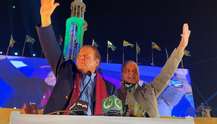 PML-N leaders Nawaz Sharif (left) and Shehbaz Sharif at the stage during a rally at Minar-e-Pakistan in Lahore, on October 21, 2023, in this still taken from a video. — X@pmln_org
