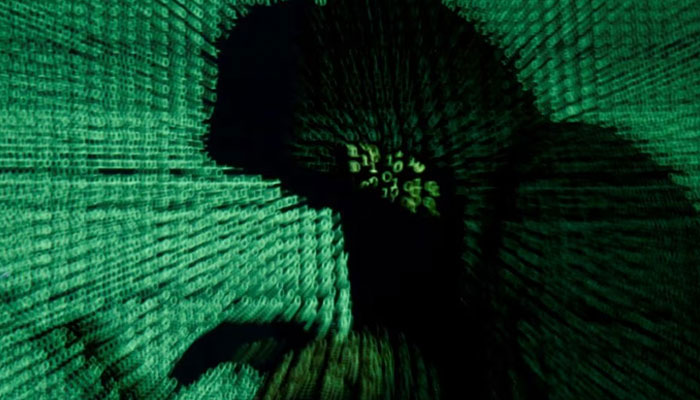 A man holds a laptop computer as cyber code is projected on him in this illustration picture. — Reuters/File
