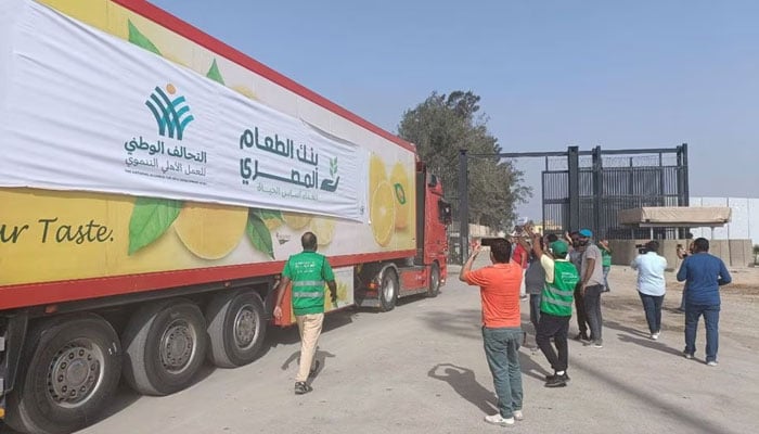Egyptian volunteers gather next to a truck carrying humanitarian aid as it drives through the Rafah crossing from the Egyptian side, amid the ongoing conflict between Israel and Palestine, in Rafah, Egypt October 22, 2023. — Reuters