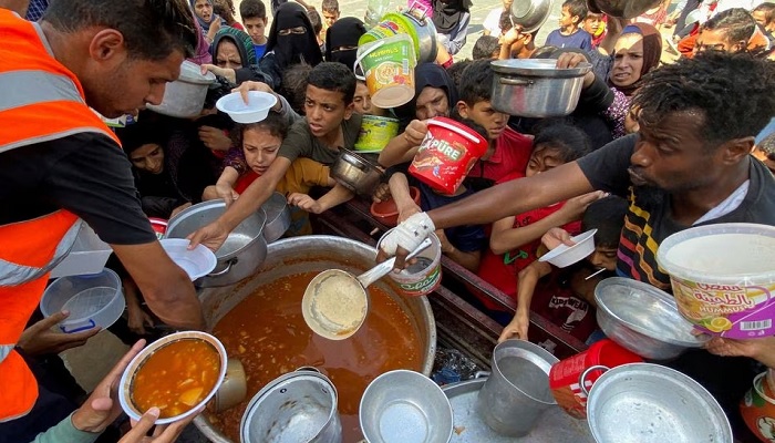 Palestinians, who fled their houses due to Israeli strikes, gather to get their share of charity food offered by volunteers, amid food shortages, at a UN-run school where they take refuge, in Rafah, in the southern Gaza Strip. — Reuters