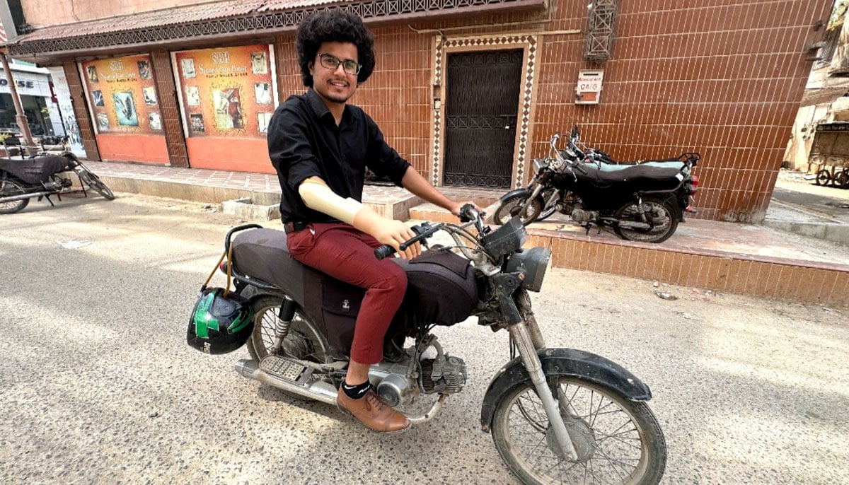 Muhammad Hamza Khan, equipped with his Bioniks AI-powered prosthetic right arm, gets set to ride a bike in Karachi on October 5, 2023. — Photo by author