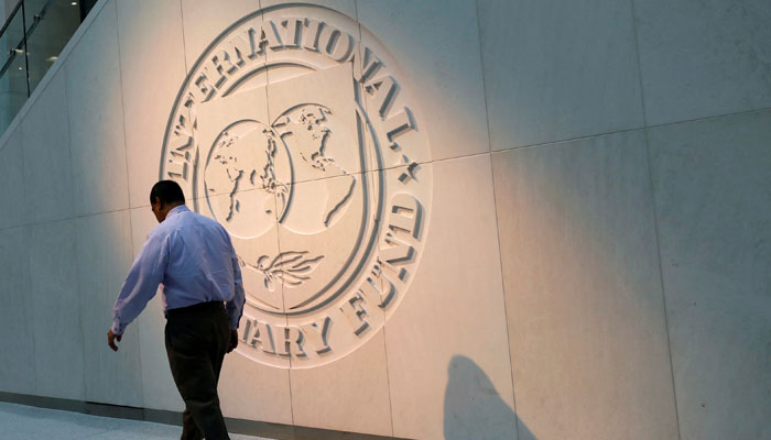 A man walks past the International Monetary Fund (IMF) logo at its headquarters in Washington, US, May 10, 2018. — Reuters